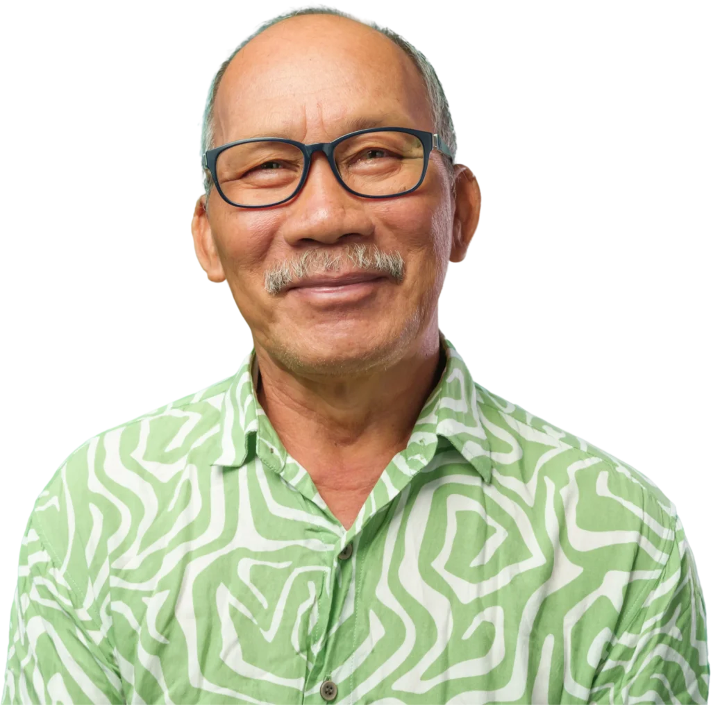 A middle-aged man wearing glasses and a green, patterned shirt, facing forward.